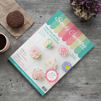 A cupcake magazine with a cup of coffee and cupcake on a table