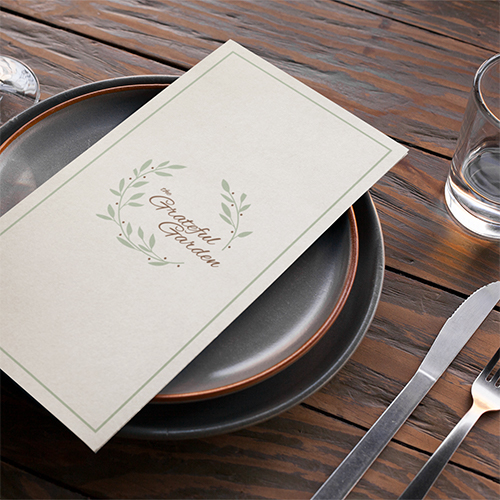 A menu on two dinner plates on a table