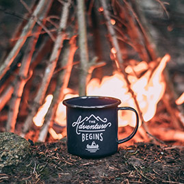 A stainless cup in front of a campfire