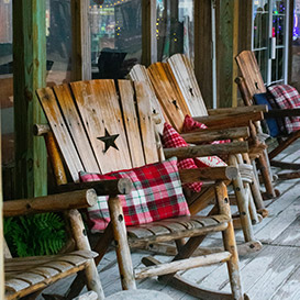 A couple of wooden rocking chairs on a porch
